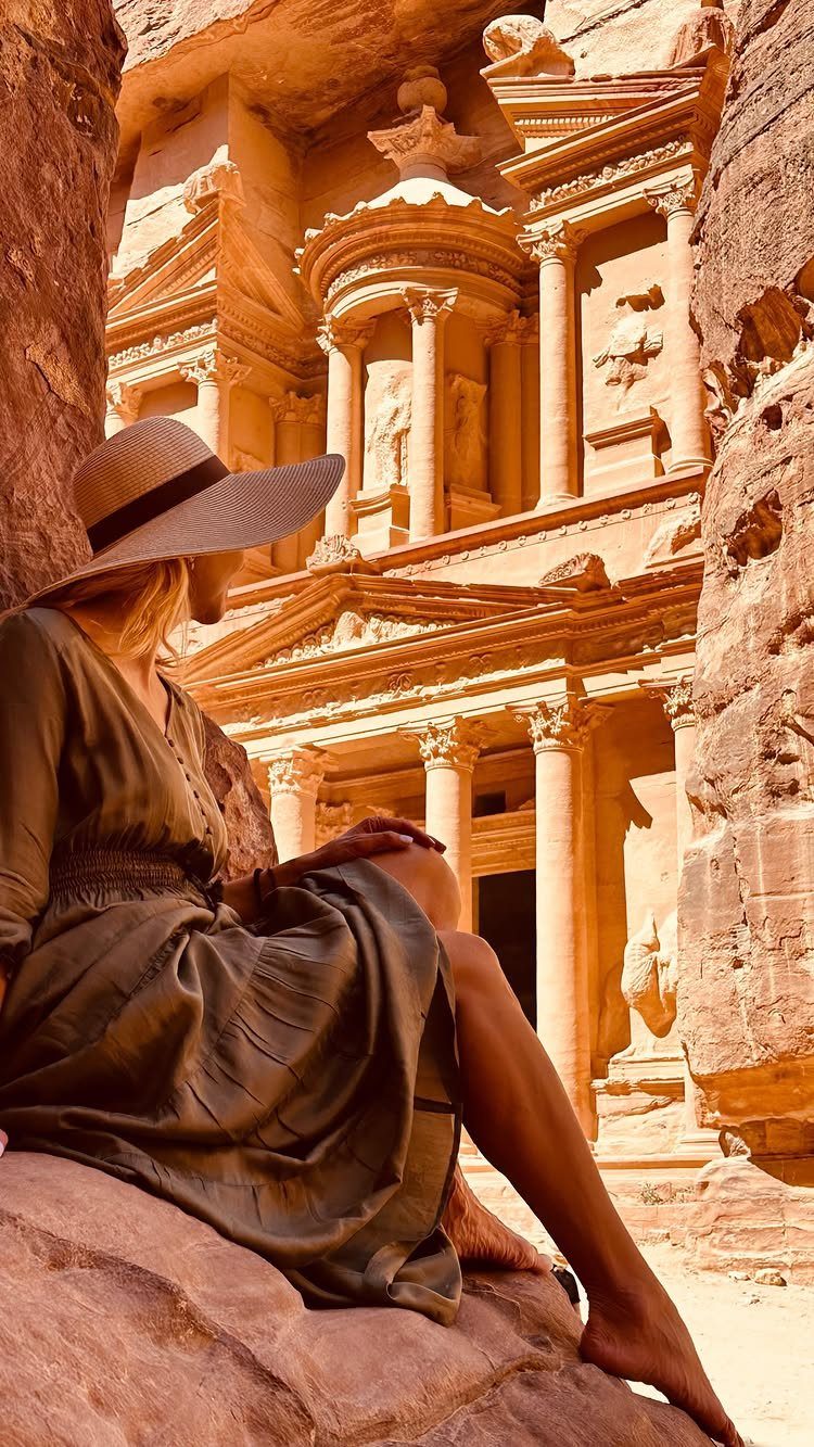 Woman in a sun hat gazing at the Treasury temple in Petra, Jordan