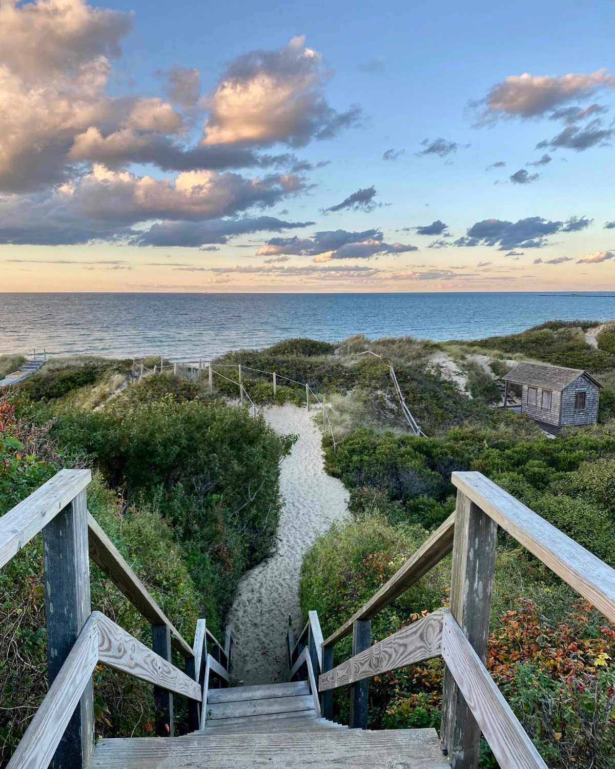 6 Beach Places to Visit, From Cape May to the Kona Coast 4 Wooden stairs leading down a sandy path to a pristine beach and ocean.