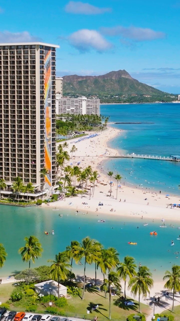 6 Beach Places to Visit, From Cape May to the Kona Coast 3 Waikiki Beach with white sand, turquoise water, tall hotels, and Diamond Head mountain.