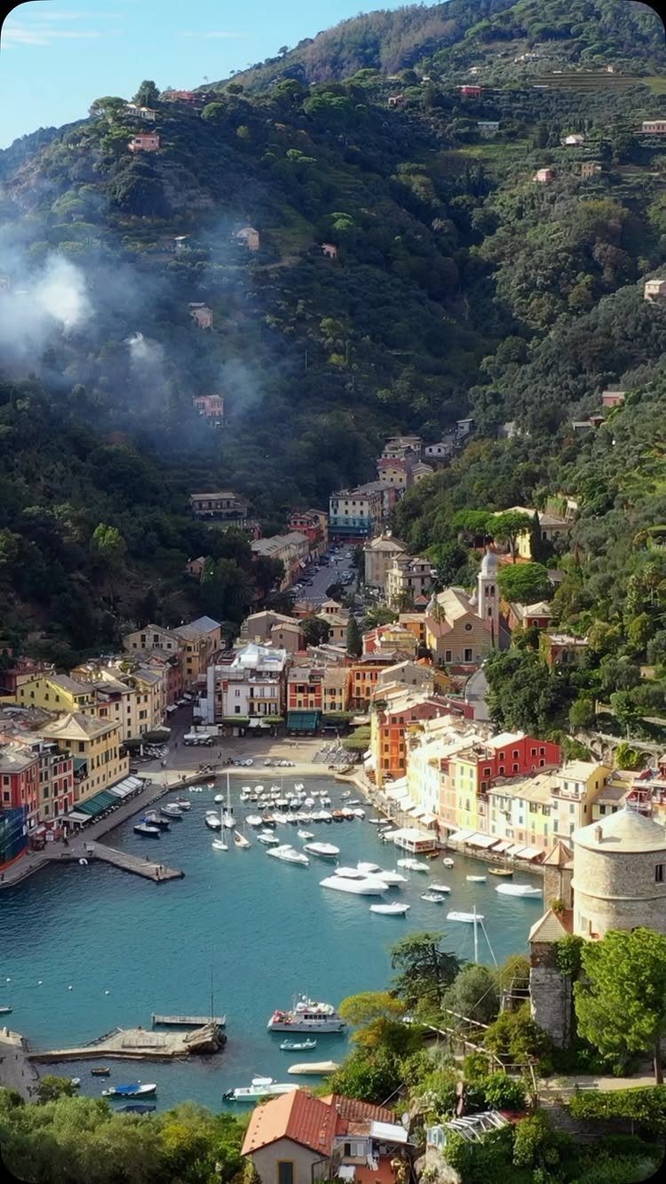28 Beautiful Places to Travel Around the World 18 Colorful coastal village buildings and a boat harbor nestled in green mountains