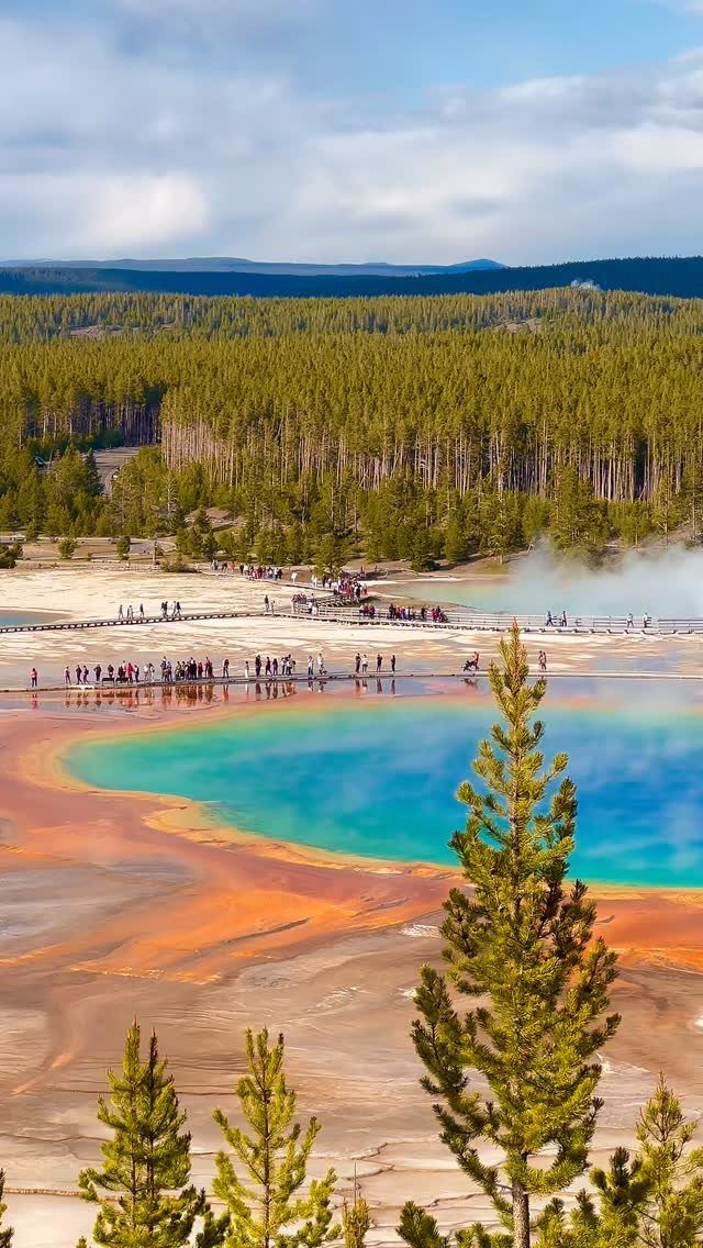 28 Beautiful Places to Travel Around the World 8 Turquoise geothermal spring with orange edges and a wooden boardwalk in Yellowstone