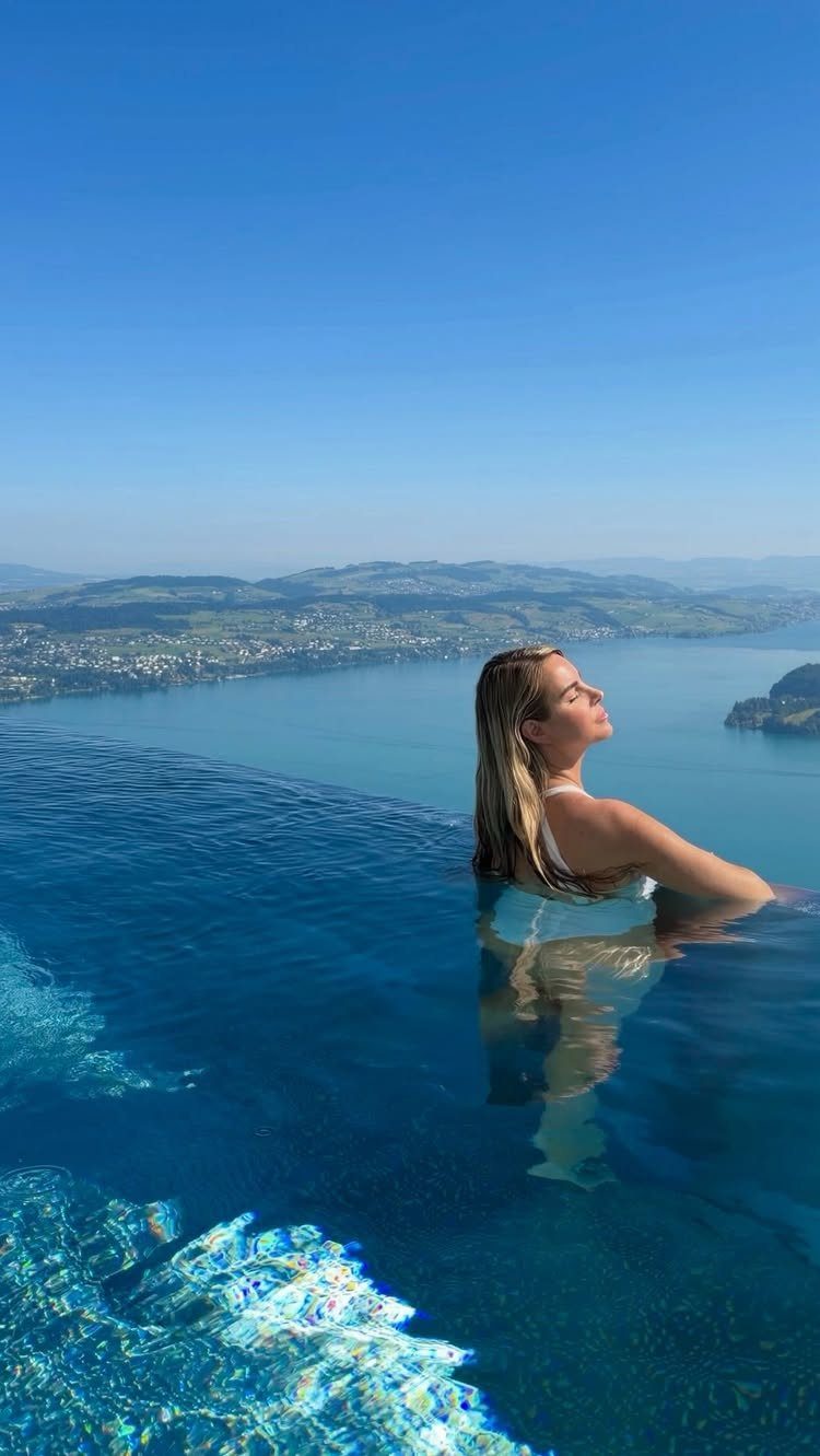 Bucket List Switzerland: 13 Scenic Places and Experiences 10 Woman relaxing in an infinity pool overlooking a Swiss lake and mountains