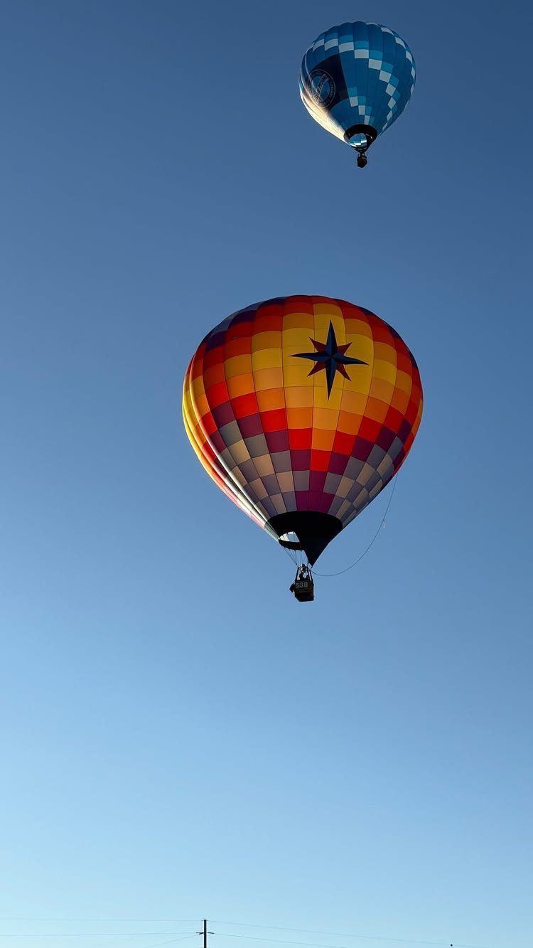 Bucket List Travel Destinations in the USA: 33 Ideas 16 Two colorful hot air balloons floating high in a clear blue sky.