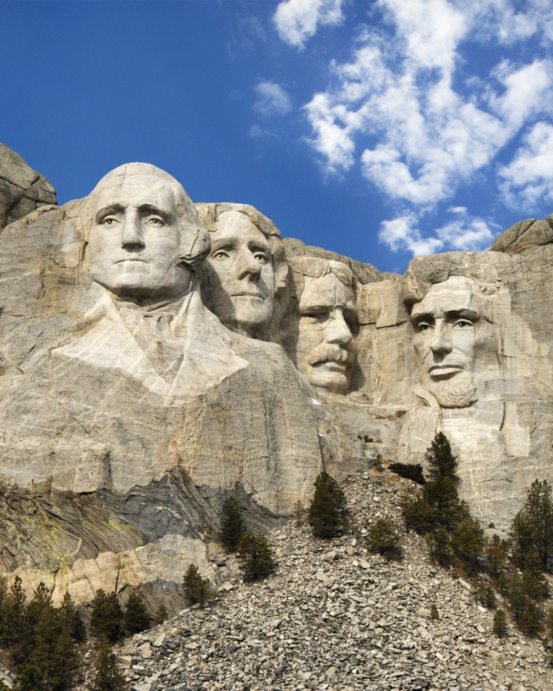 Bucket List Travel Destinations in the USA: 33 Ideas 6 Mount Rushmore monument with four presidential faces carved into a granite mountain side.
