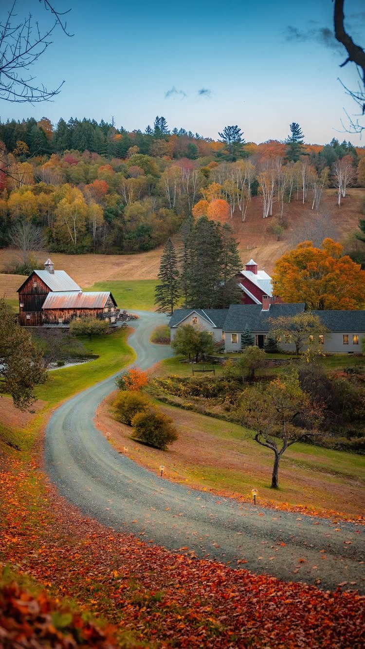 Bucket List Travel Destinations in the USA: 33 Ideas 32 Winding gravel road leading to red barns amidst colorful autumn foliage in New England.