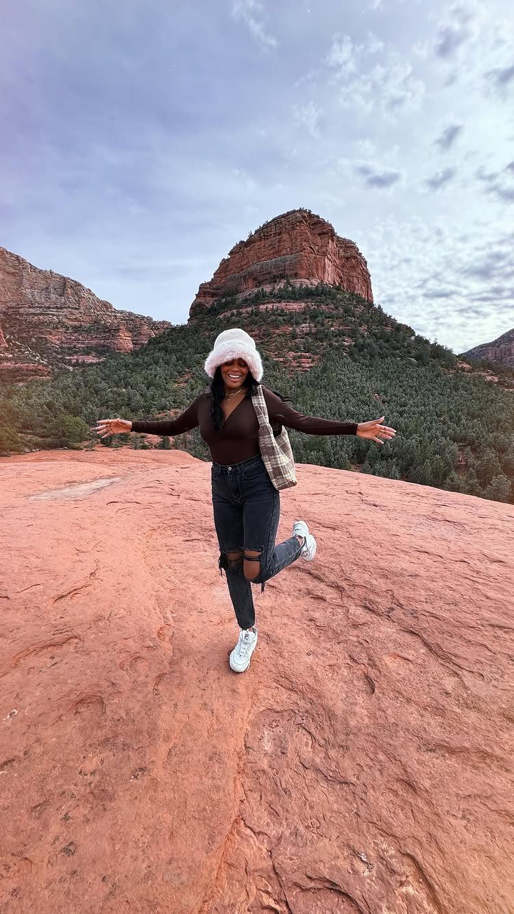 Bucket List Travel Destinations in the USA: 33 Ideas 12 Woman posing on a red sandstone plateau with red rock formations in Sedona.