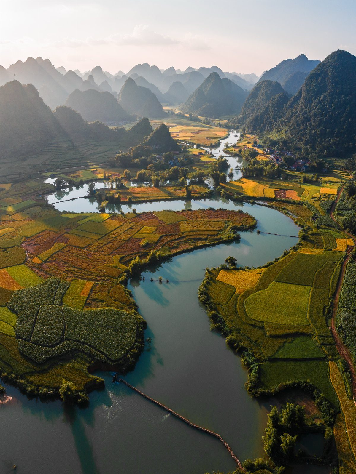 16 Cheap Pretty Places to Travel on a Tight Budget 10 Winding river flowing through colorful farmland surrounded by steep karst mountains