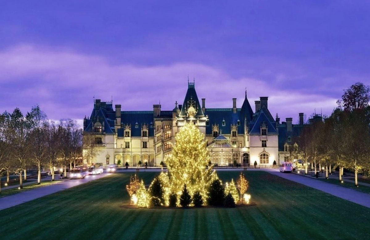 14 Christmas Places to Visit for Holiday Lights and Markets 3 Large historic stone estate with a massive glowing Christmas tree on the front lawn