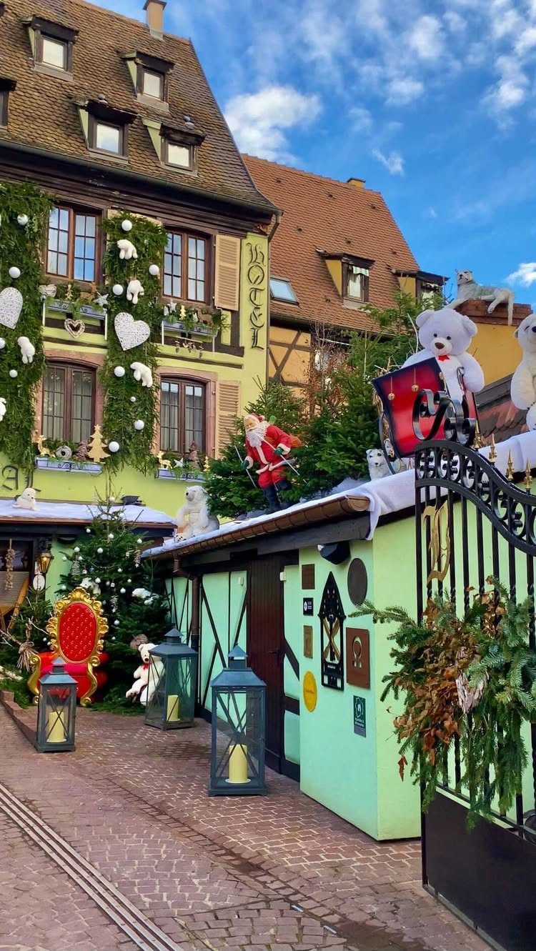 14 Christmas Places to Visit for Holiday Lights and Markets 7 Festive European street with decorated half-timbered houses, lanterns, and Christmas ornaments in Colmar.