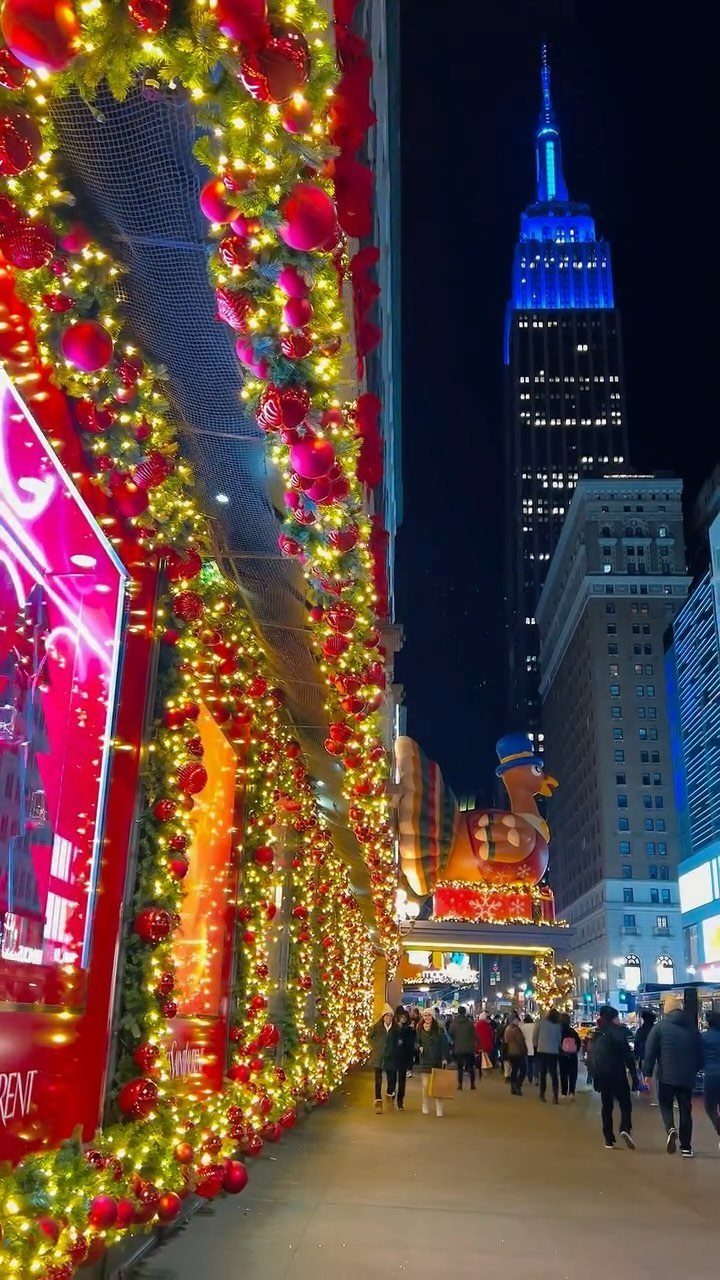 14 Christmas Places to Visit for Holiday Lights and Markets 12 Christmas garland with red ornaments lining a city street with the Empire State Building.