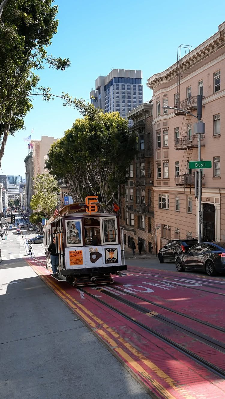 12 Cities to Visit in the U.S. and Abroad for 2026 2 Vintage cable car climbing a steep San Francisco street lined with historic buildings.