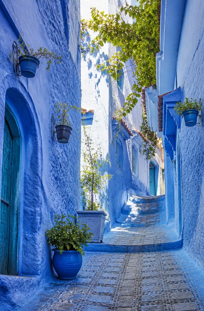 Narrow alleyways in Chefchaouen with blue-painted buildings.