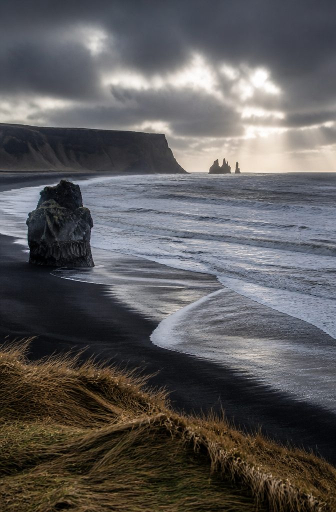 Dream Vacations Destinations for 2026: The Places Worth Going 6 A varied landscape in Iceland showing black sand beaches and rugged terrain.