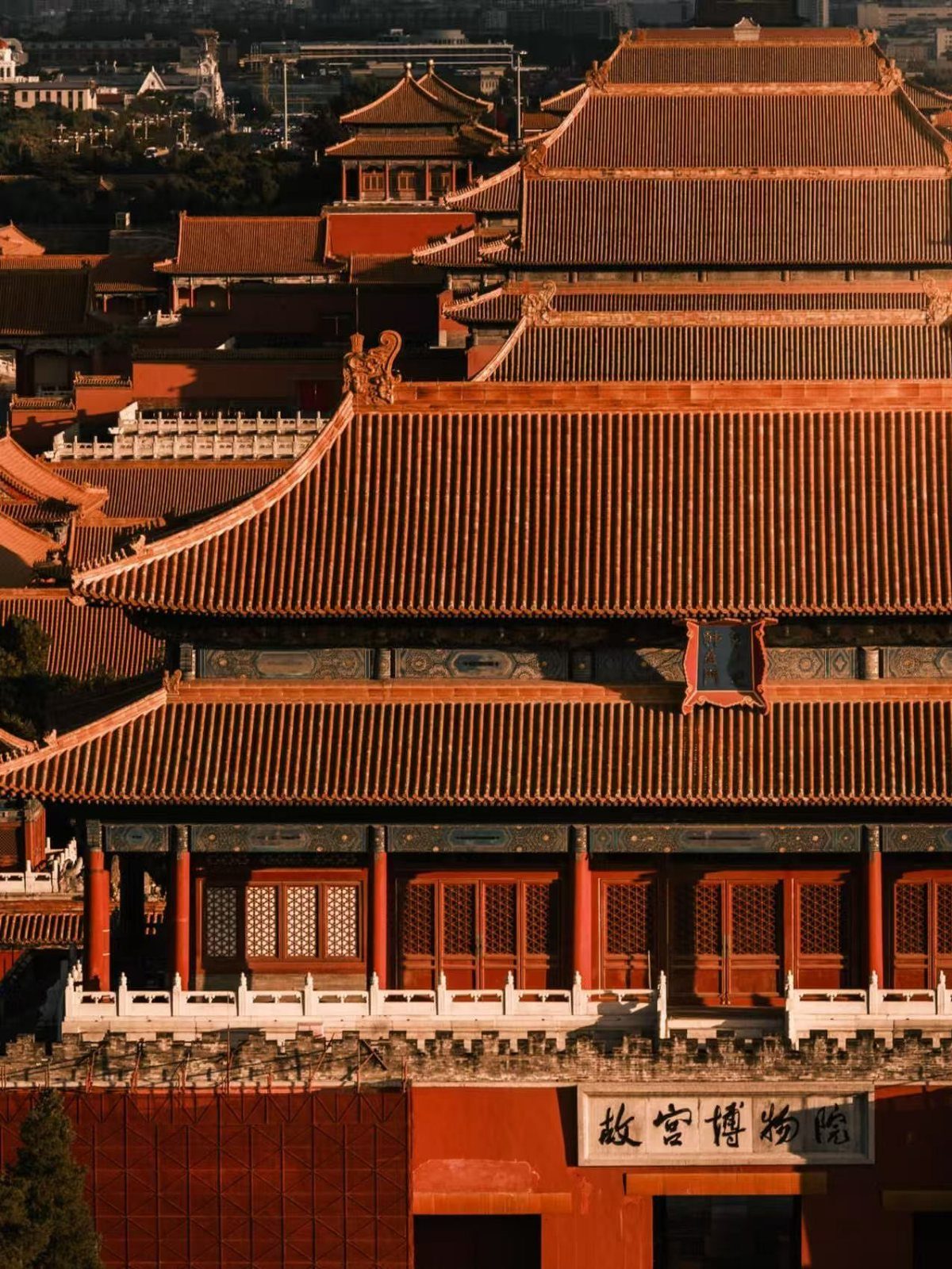 Traditional Chinese palace buildings with orange tiled roofs and red walls in Beijing.