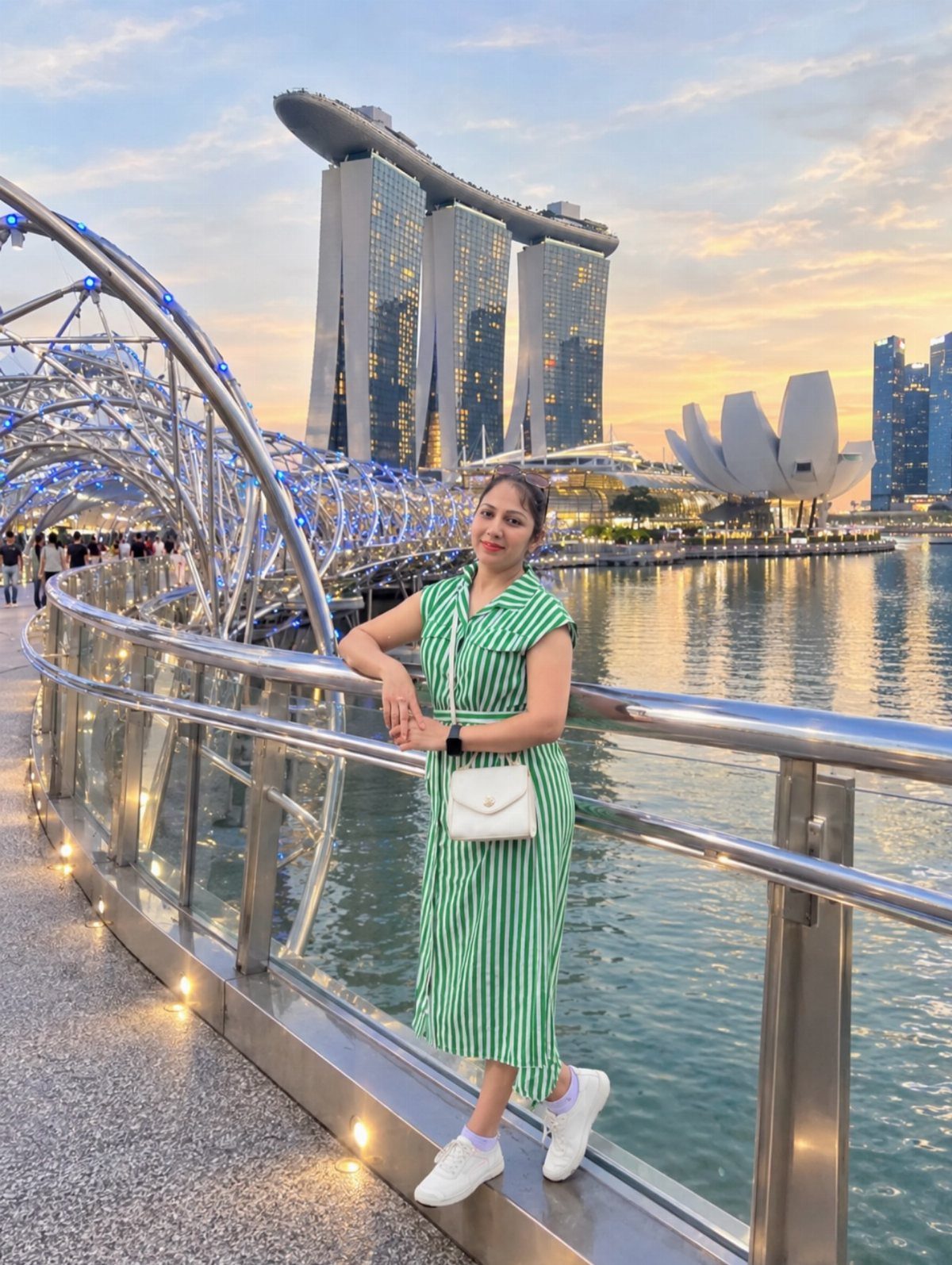 Woman in green dress posing before Marina Bay Sands and ArtScience Museum in Singapore