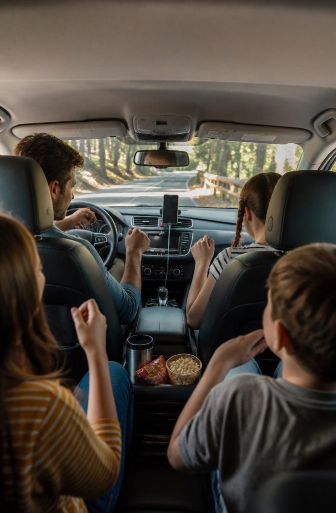 A family enjoying music from a smartphone in their car.