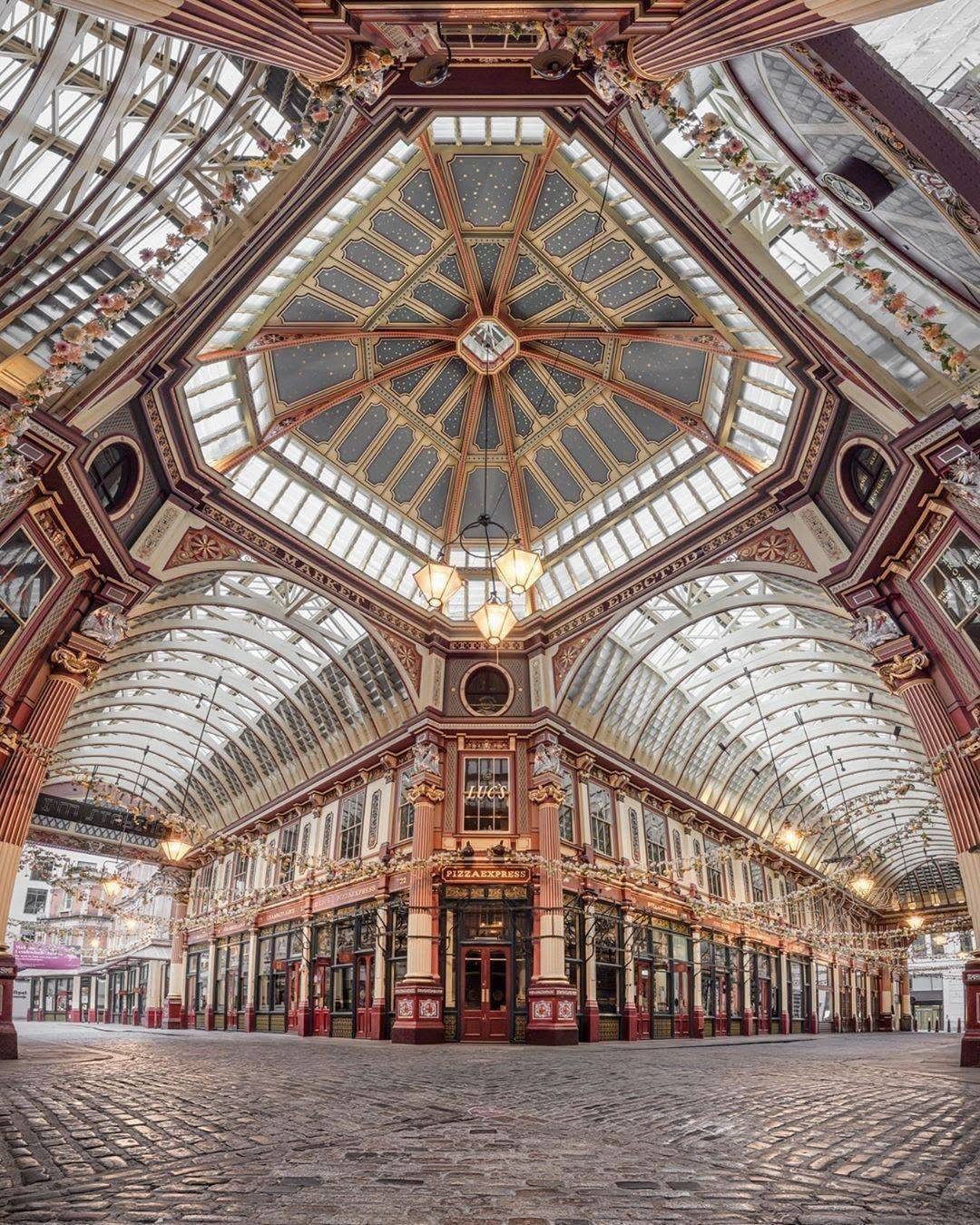 Leadenhall Market interior with ornate red architecture and a grand glass ceiling.