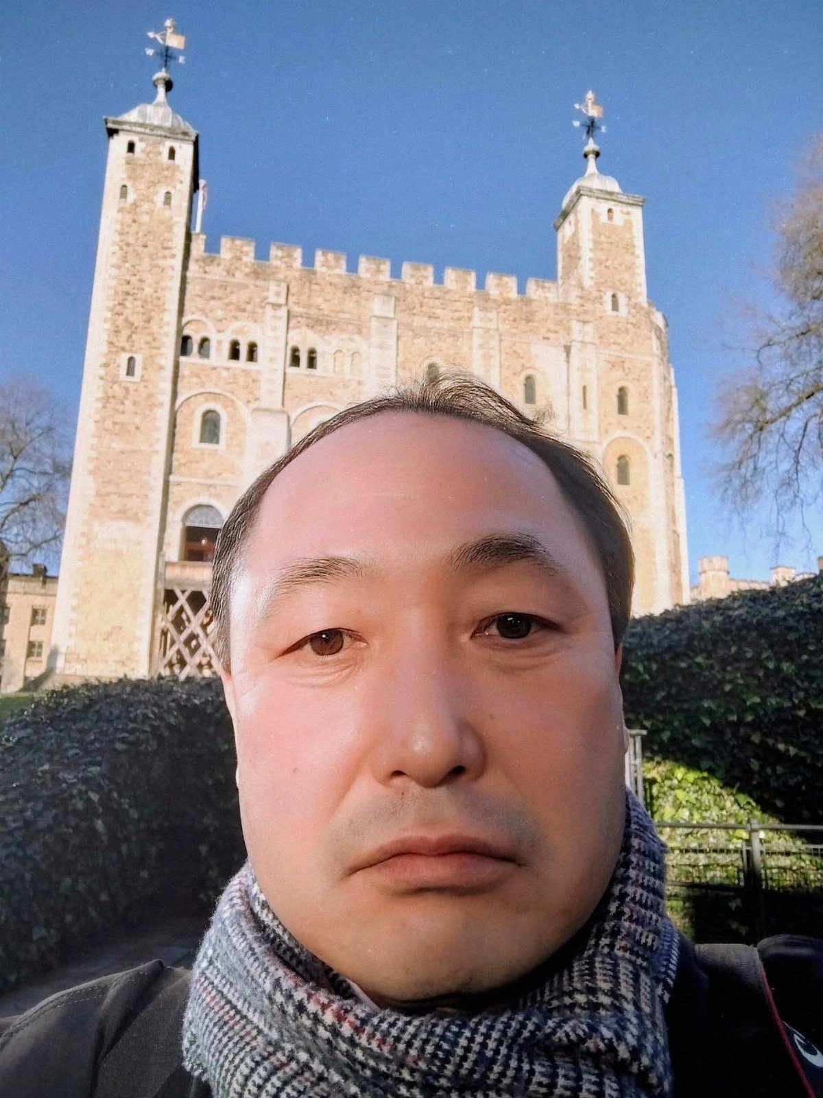 Man in a scarf posing in front of the Tower of London