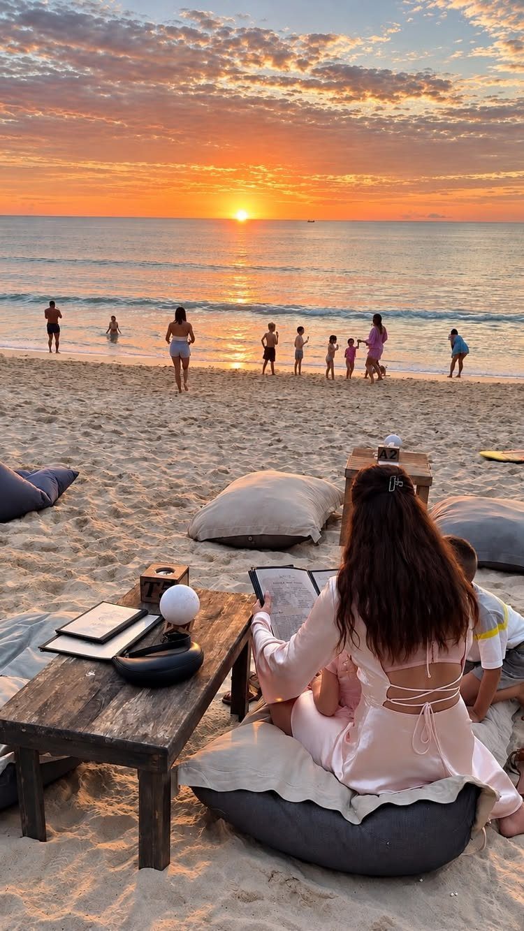 12 November Trip Ideas for Warm Beaches and Fall Color 5 Woman sitting on a beach beanbag watching a vibrant orange sunset over the ocean