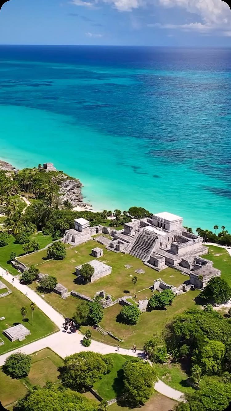 12 November Trip Ideas for Warm Beaches and Fall Color 3 Ancient Mayan ruins on a green cliff overlooking turquoise ocean waters in Tulum.