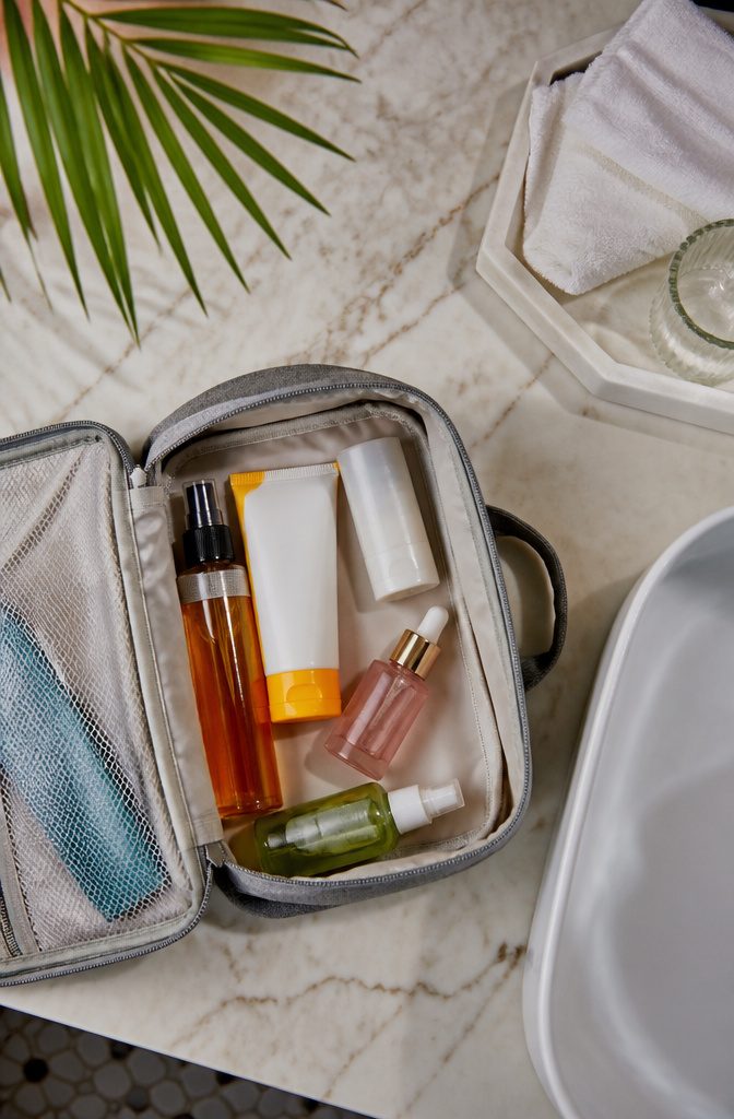 A toiletries kit with various travel-sized bottles on a table.