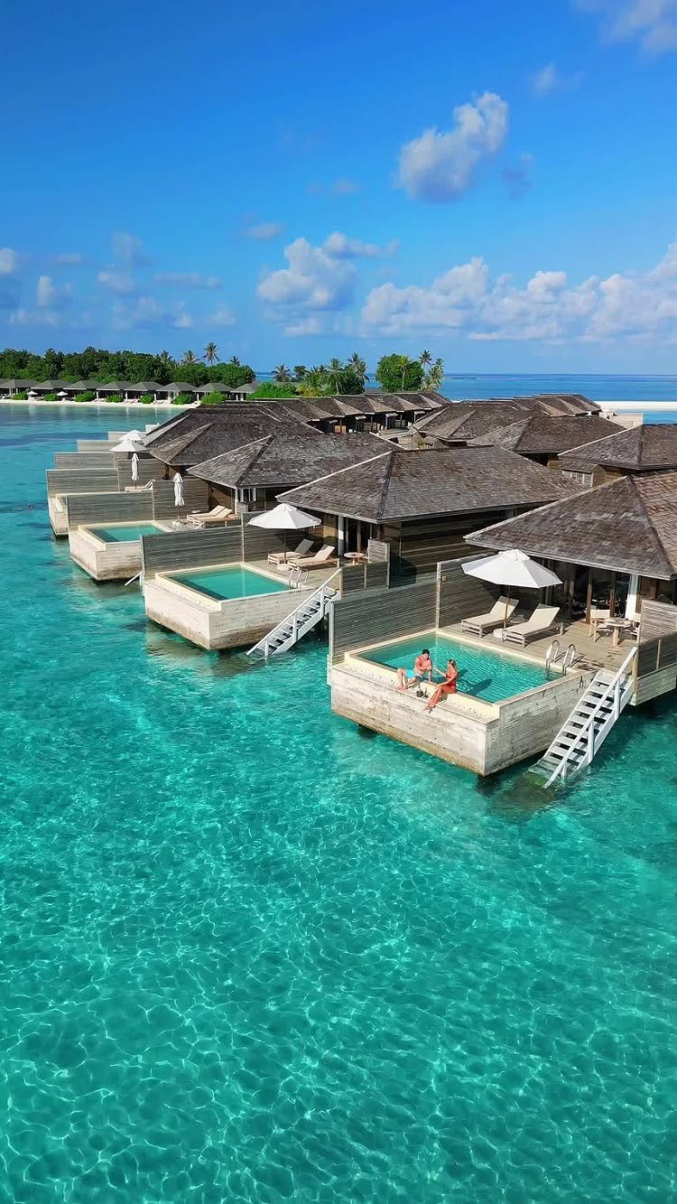 Overwater bungalows with private pools floating on clear turquoise tropical ocean water