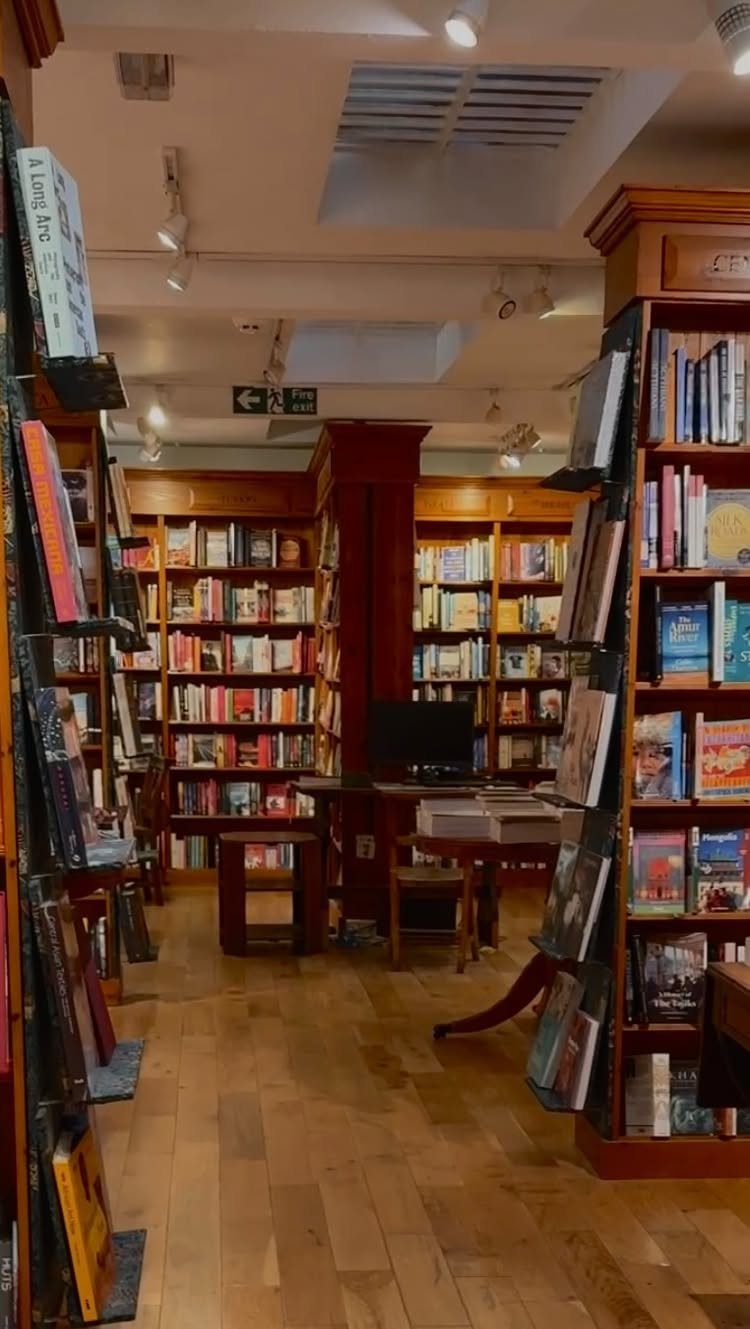 Wooden bookshelves filled with books in a cozy, well-lit bookstore interior.