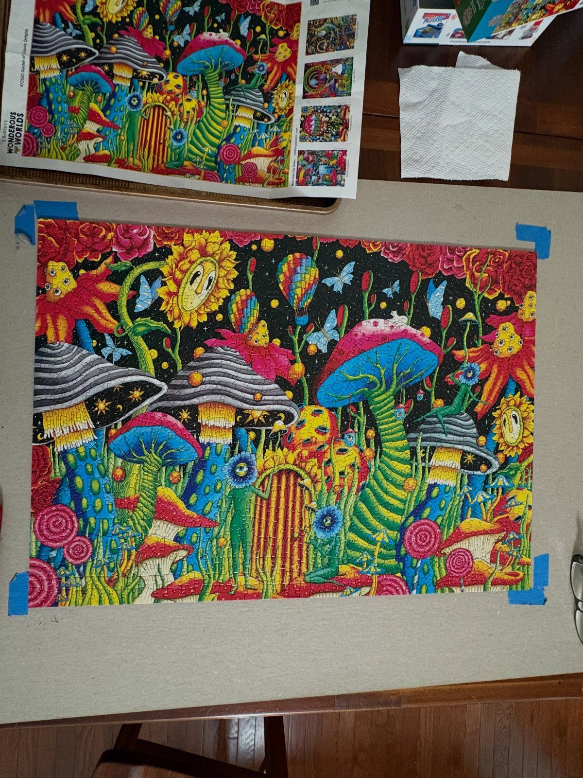 Completed colorful jigsaw puzzle of a psychedelic mushroom forest on a beige board.