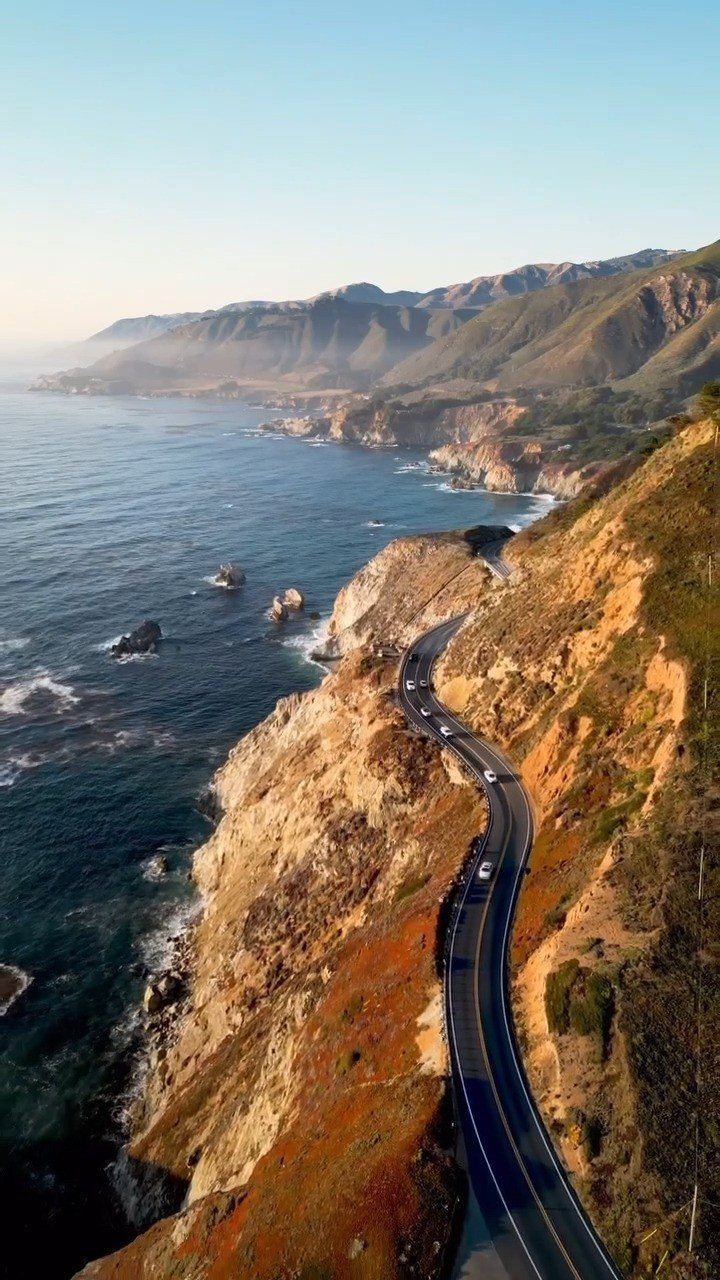 14 Places to Travel With Family: Beaches, Parks and Cities 3 Winding coastal road curving along steep cliffs beside a vast blue ocean.