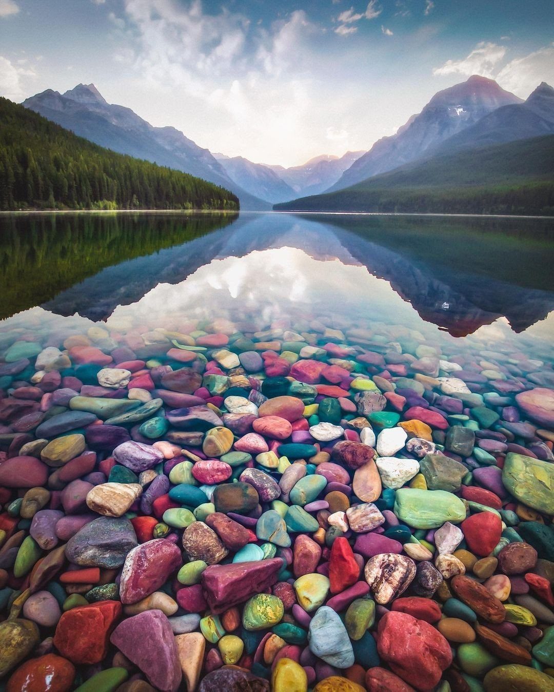 14 Places to Travel With Family: Beaches, Parks and Cities 10 Colorful pebbles underwater with a reflection of mountains in a clear lake