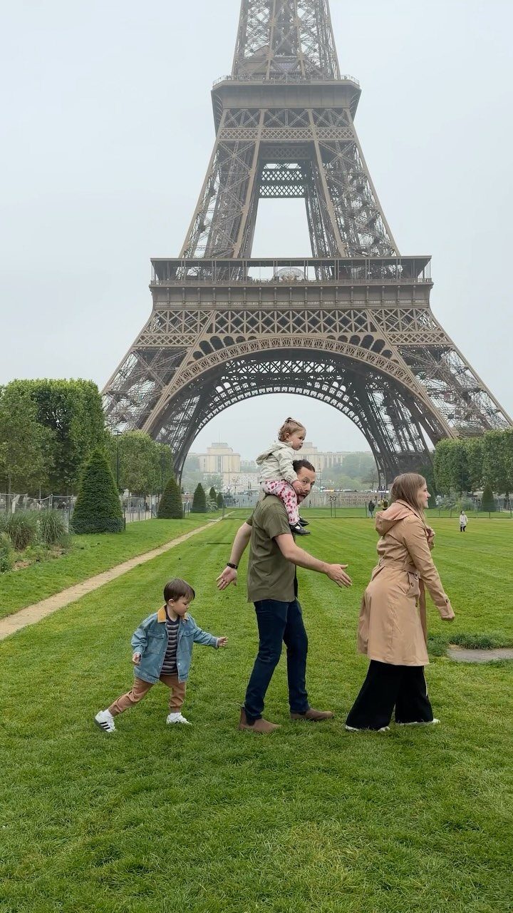 14 Places to Travel With Family: Beaches, Parks and Cities 13 Family with two children walking on a lawn before the Eiffel Tower in Paris.