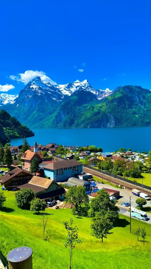 14 Places to Travel With Family: Beaches, Parks and Cities 11 Small village by a blue lake with snow-capped mountains in the background.