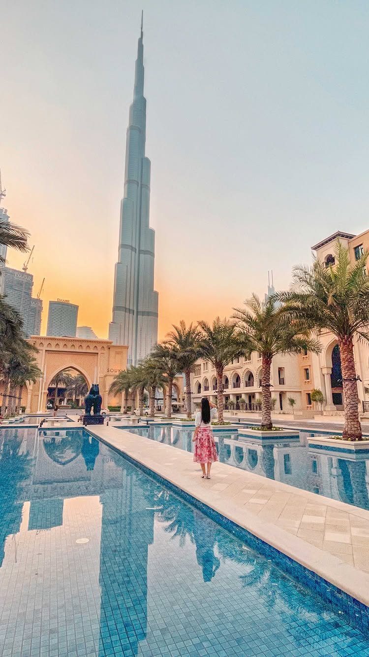 Places to Visit Around the World: 23 Ideas With Photos 16 Burj Khalifa skyscraper towering over luxury pools and palm trees in Dubai at sunset