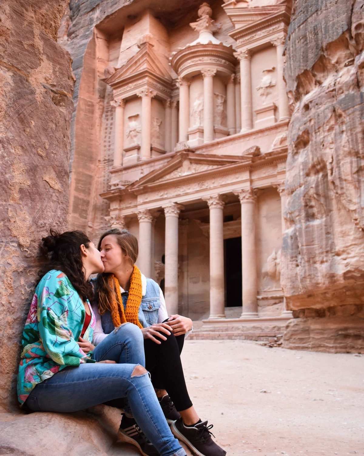 Places to Visit Around the World: 23 Ideas With Photos 13 Two women kissing in front of the carved sandstone Treasury building in Petra, Jordan.