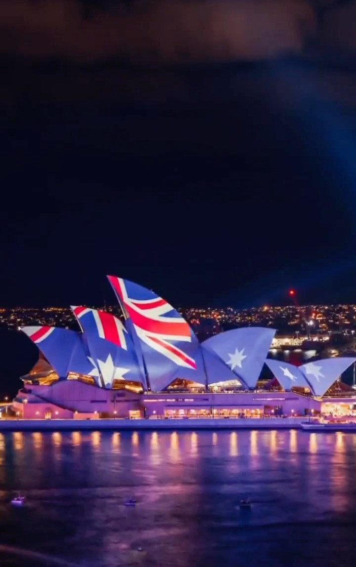 Places to Visit Around the World: 23 Ideas With Photos 2 Sydney Opera House at night with the Australian flag projected on its sails.