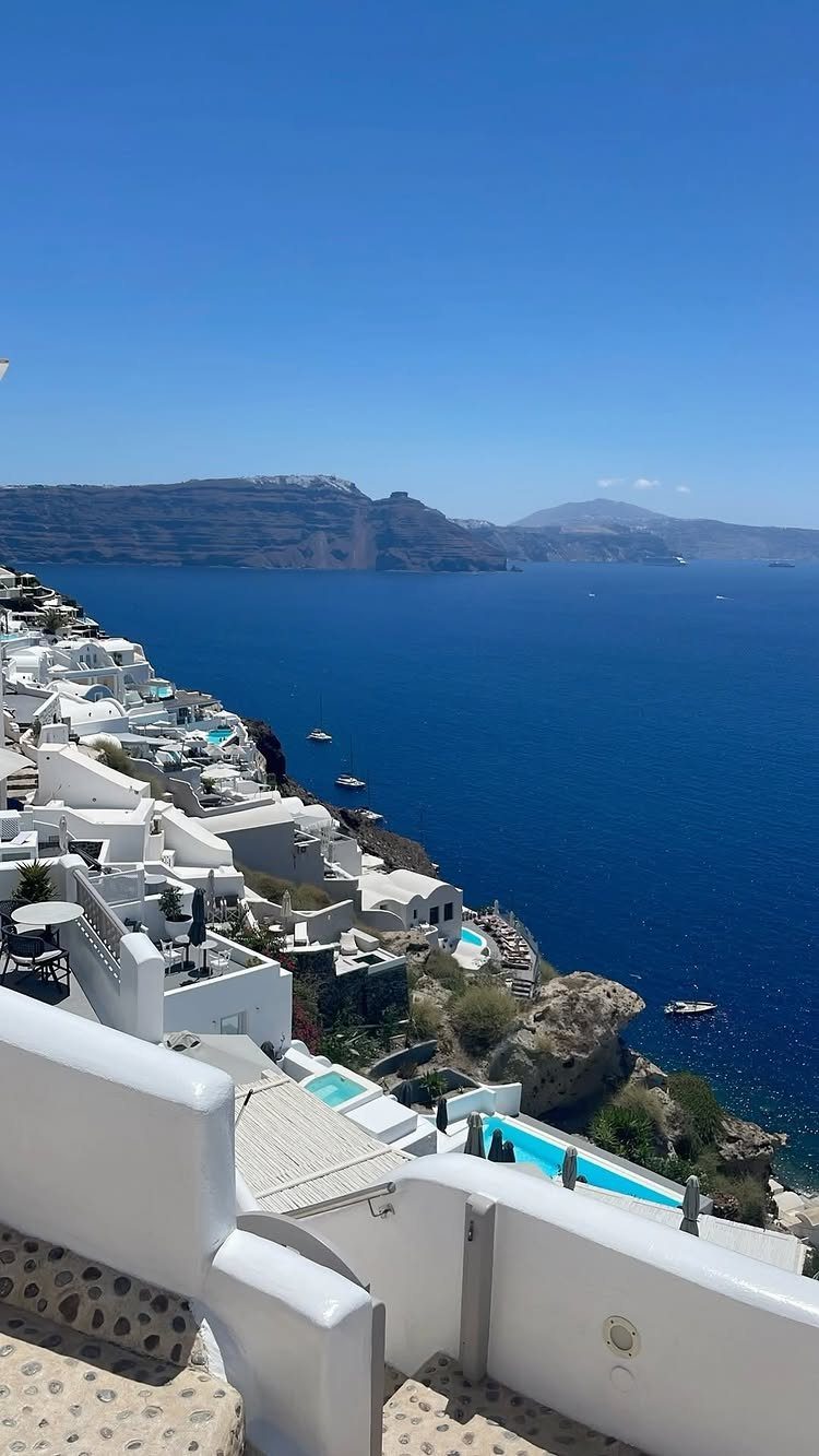 Places to Visit Around the World: 23 Ideas With Photos 7 White buildings on a cliff overlooking the deep blue sea in Santorini