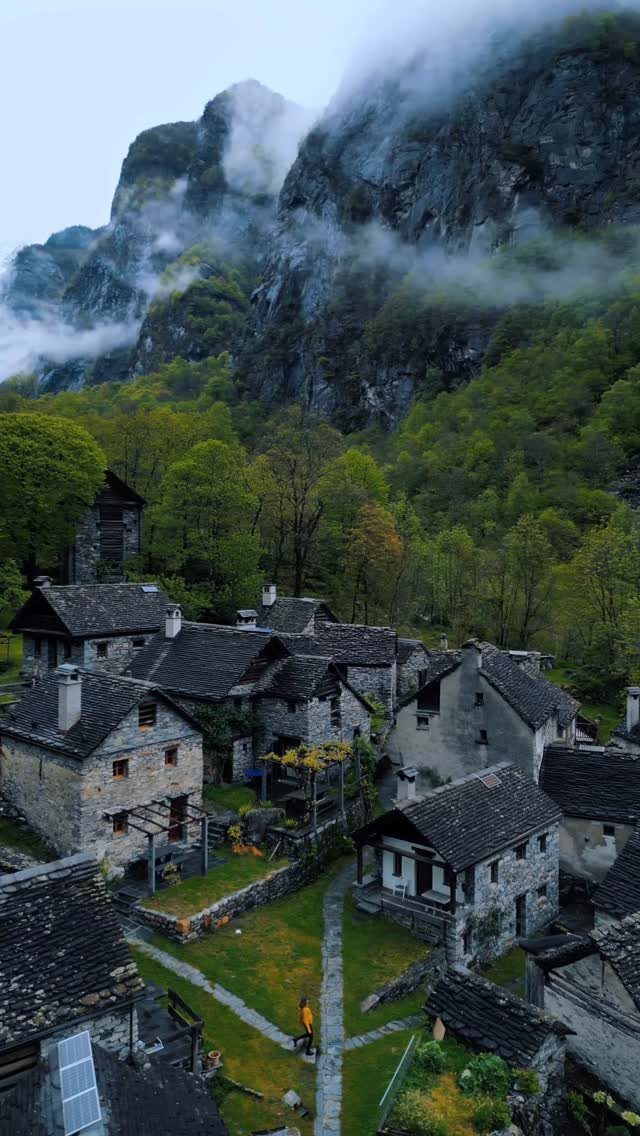 Prettiest Place to Visit: 21 Ideas Around the World 18 Stone village houses nestled in a green valley beneath misty rocky mountains.
