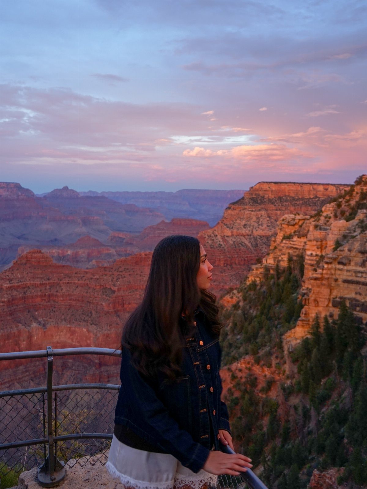 Prettiest Place to Visit: 21 Ideas Around the World 2 Woman looking over the red rock vistas of the Grand Canyon at sunset.