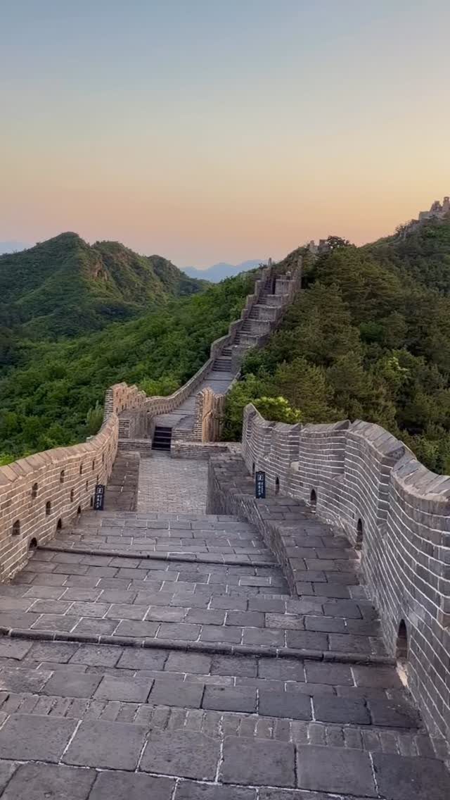 Prettiest Place to Visit: 21 Ideas Around the World 7 The Great Wall of China winding across green mountain ridges at sunset.