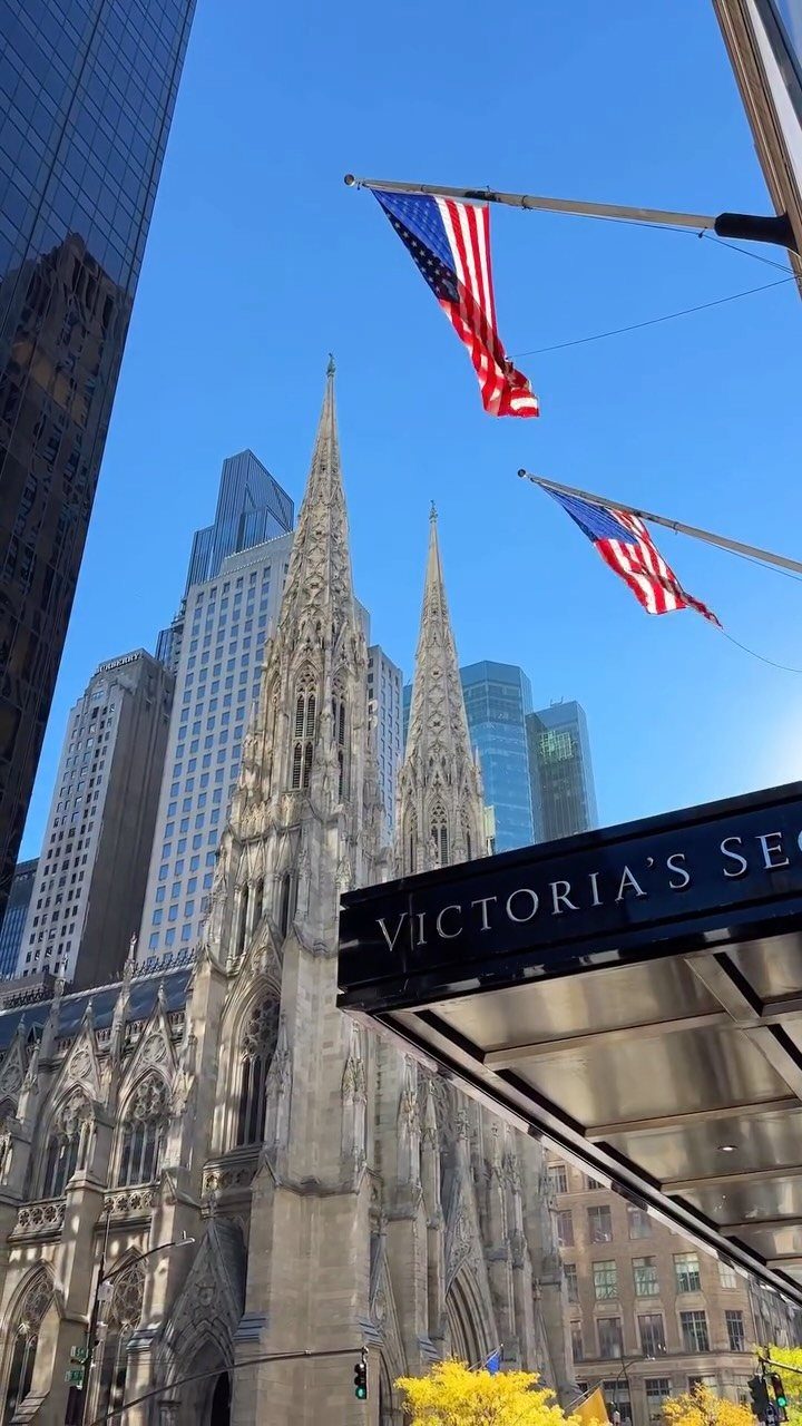 Prettiest Place to Visit: 21 Ideas Around the World 1 St. Patrick's Cathedral spires and American flags against a blue city skyline.