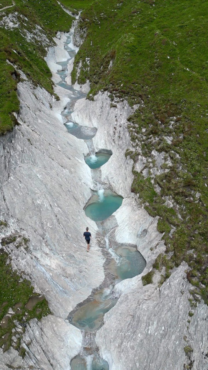Prettiest Place to Visit: 21 Ideas Around the World 19 Rocky canyon with turquoise pools and a person standing by the stream