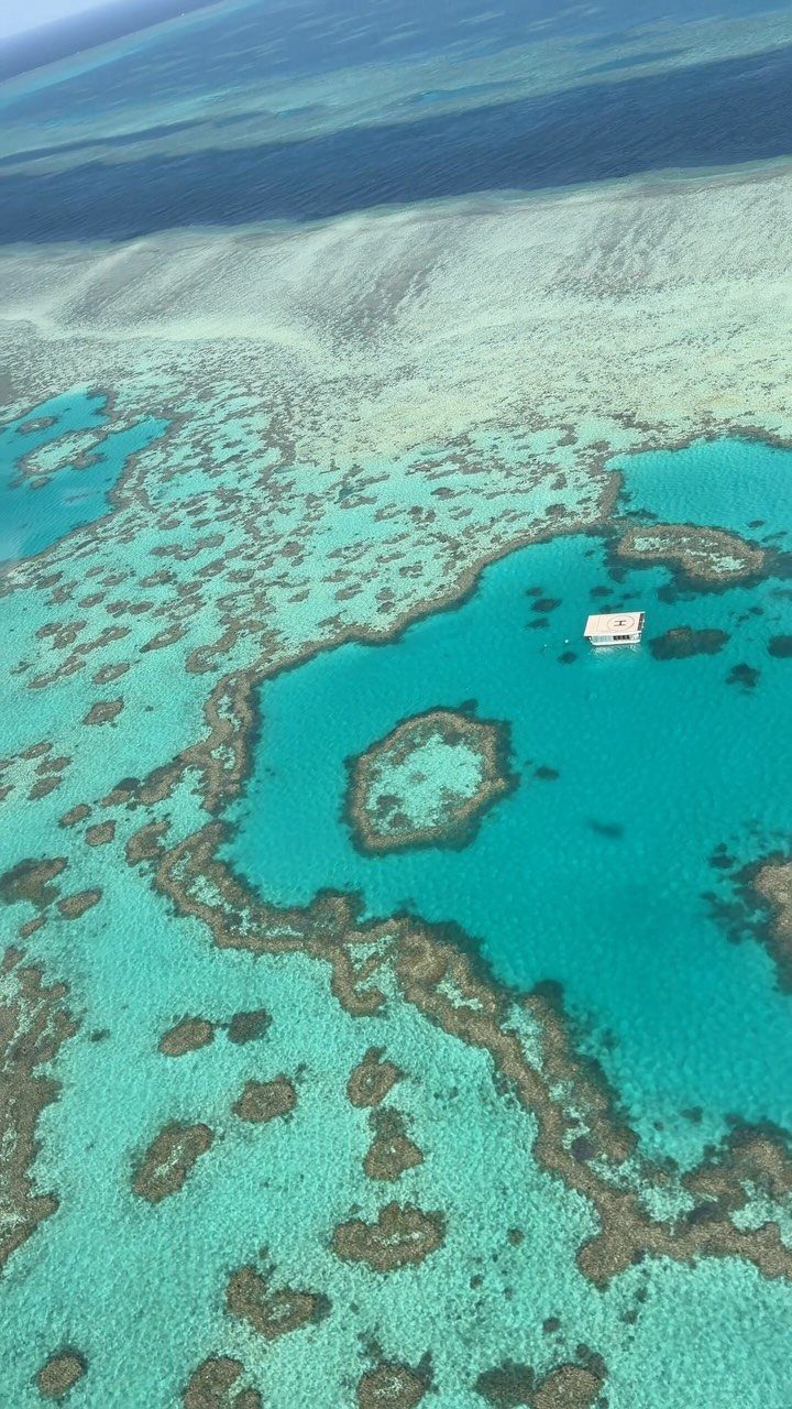 13 Pretty Countries to Visit for Coasts, Peaks and Ruins 6 Coral reef formations in turquoise ocean water with a small white boat