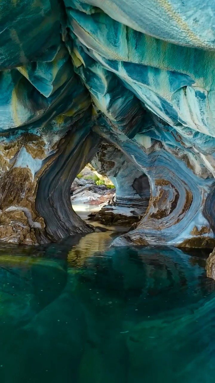 26 Pretty Places Around the World, From Fjords to Falls 8 Swirling blue and white marble caves reflecting in clear turquoise water in Patagonia.