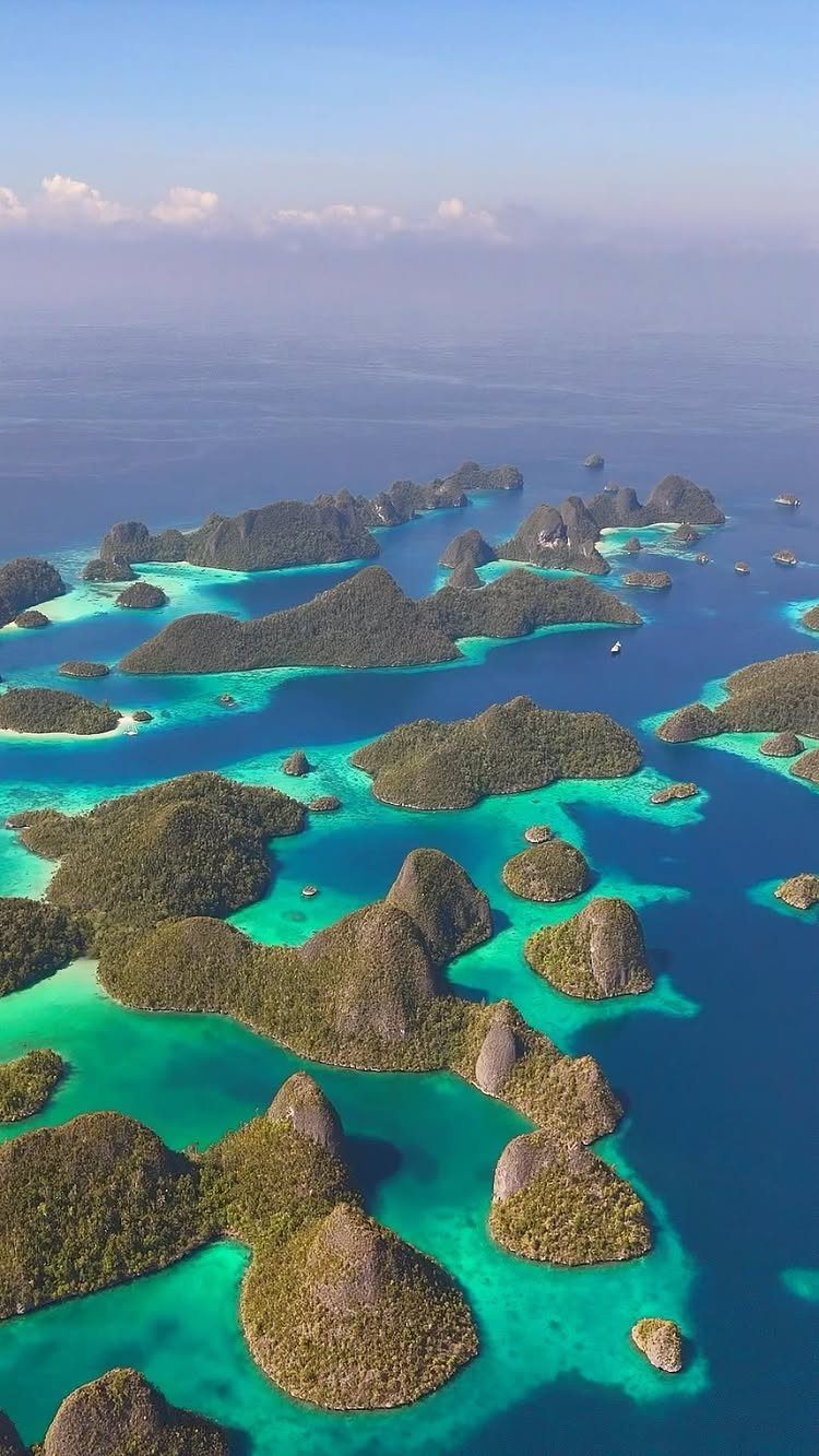 26 Pretty Places Around the World, From Fjords to Falls 9 Lush green karst islands scattered across turquoise and deep blue tropical waters.