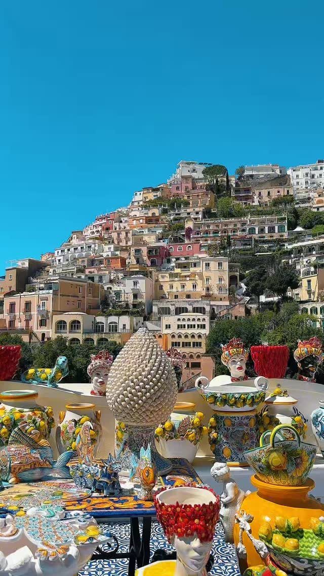 13 Pretty Places in Italy Worth Visiting in 2026 3 Colorful ceramic pottery overlooking a hillside village of pastel buildings under blue sky.