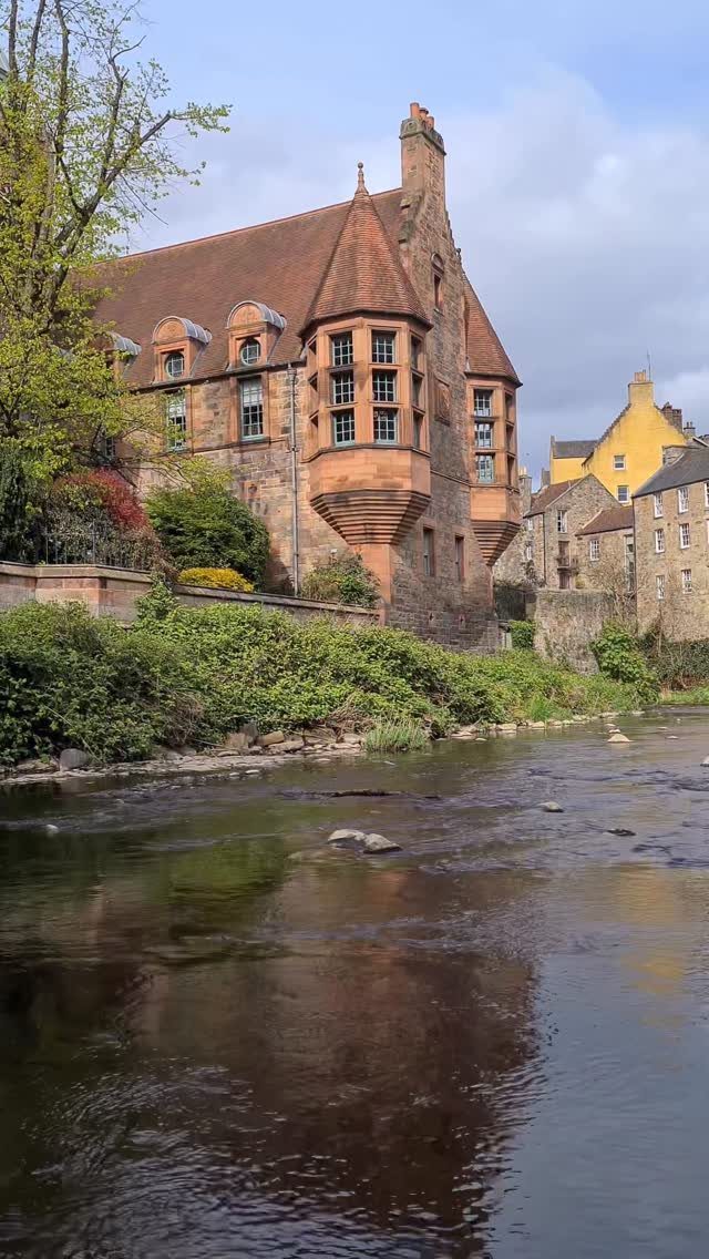 Stone buildings with red roofs overlooking a calm river in Dean Village