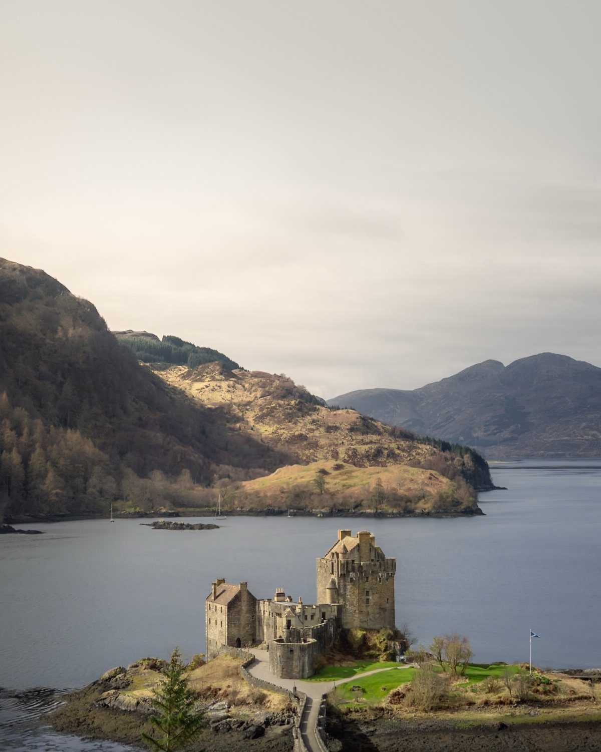 Eilean Donan Castle on a small island surrounded by water and mountains.