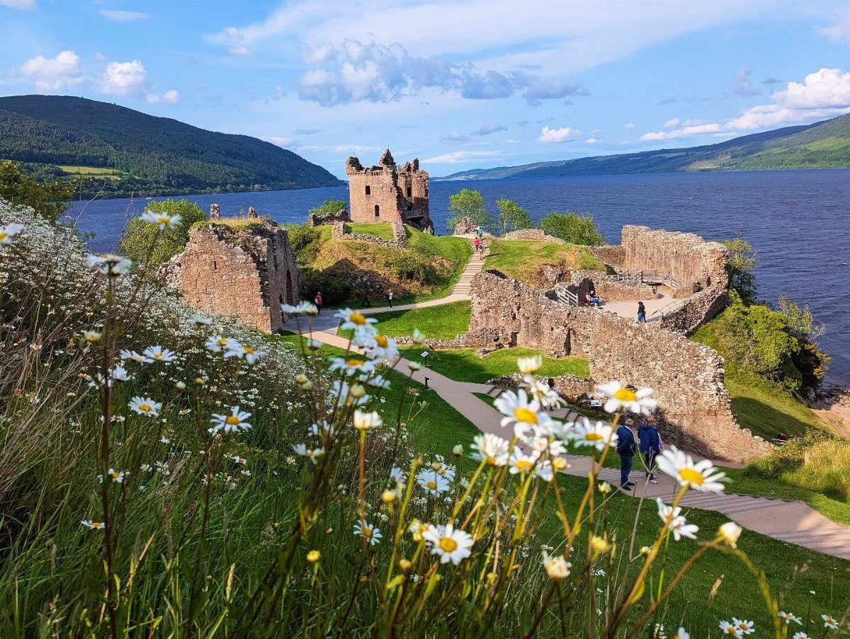 Urquhart Castle ruins overlooking the blue waters of Loch Ness in Scotland.