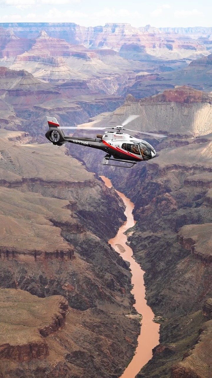 7 Sights to See in the US, From Acadia to Old Idaho 5 Helicopter flying over the deep canyons and winding river of Grand Canyon National Park