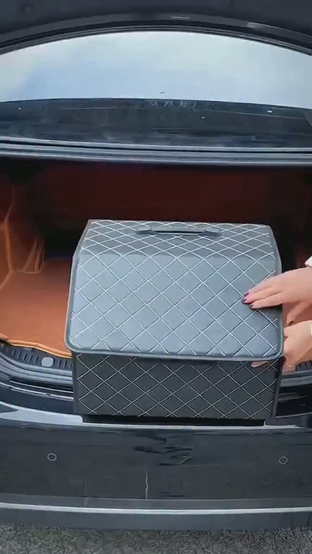 Grey quilted storage box sitting in the open trunk of a black car.